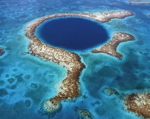 The Great Blue Hole from the air, a deep blue circle in a turquoise reef