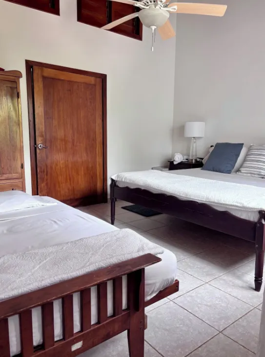 A bedroom with a second bed pulled out beside the first