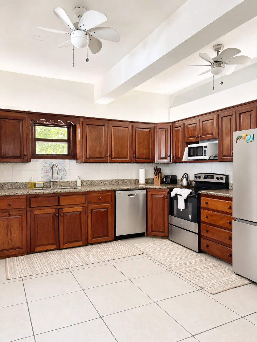 The kitchen, with wood cabinets, stone counters and stainless steel appliances